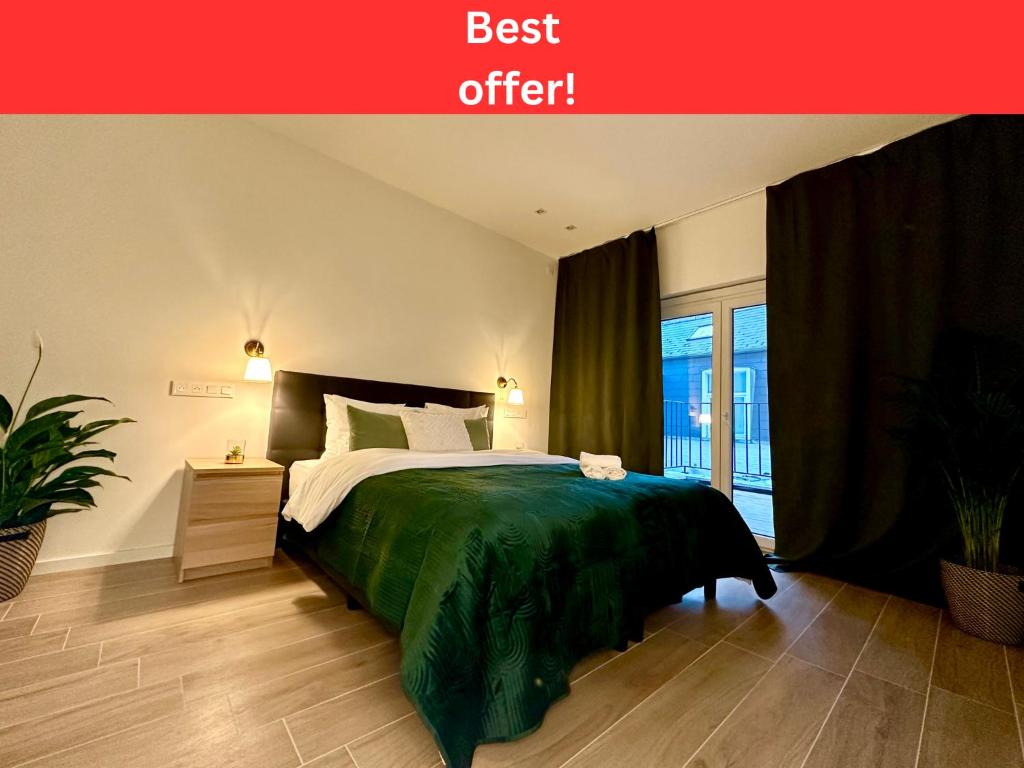 a bedroom with a bed with a green blanket at Luxury Suites Park by Rikas Hotels in Antwerp