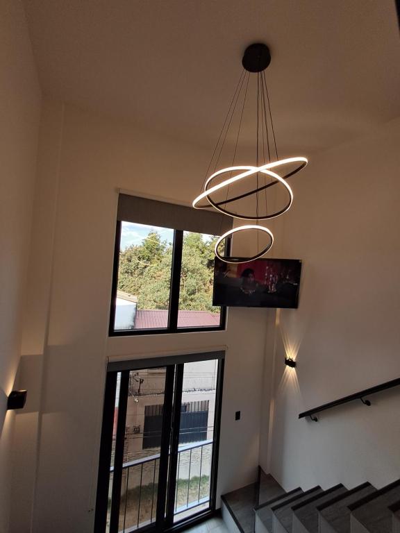 a room with a large window and a chandelier at 7min del Parque Central-2min Rotonda Marimba, en la naturaleza Tipo LOFT5 in Quetzaltenango