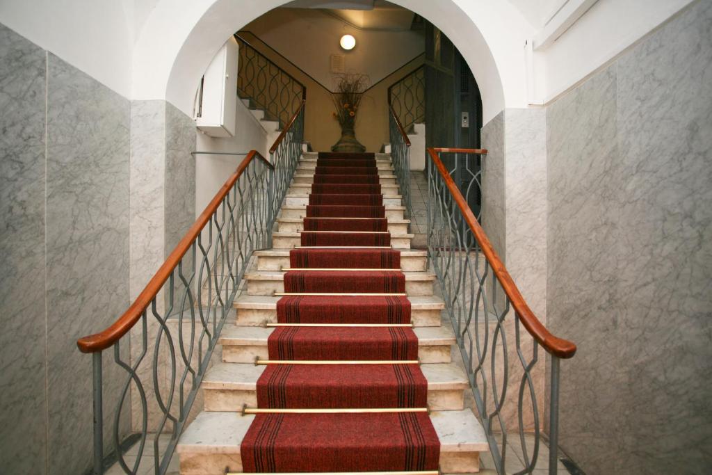 a staircase with red carpeted stairs in a building at La Giara del Centro in La Spezia