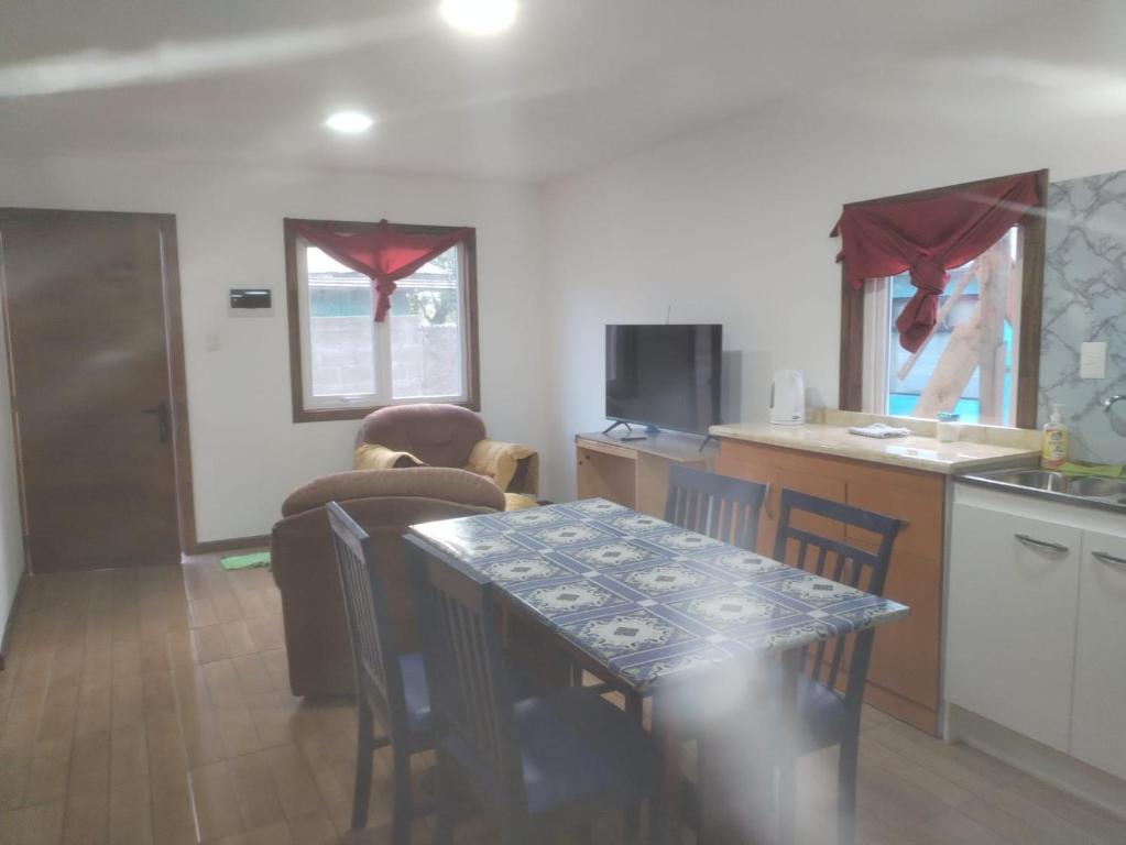 a kitchen and dining room with a table and chairs at Cabañas Drü 3 in Coihaique