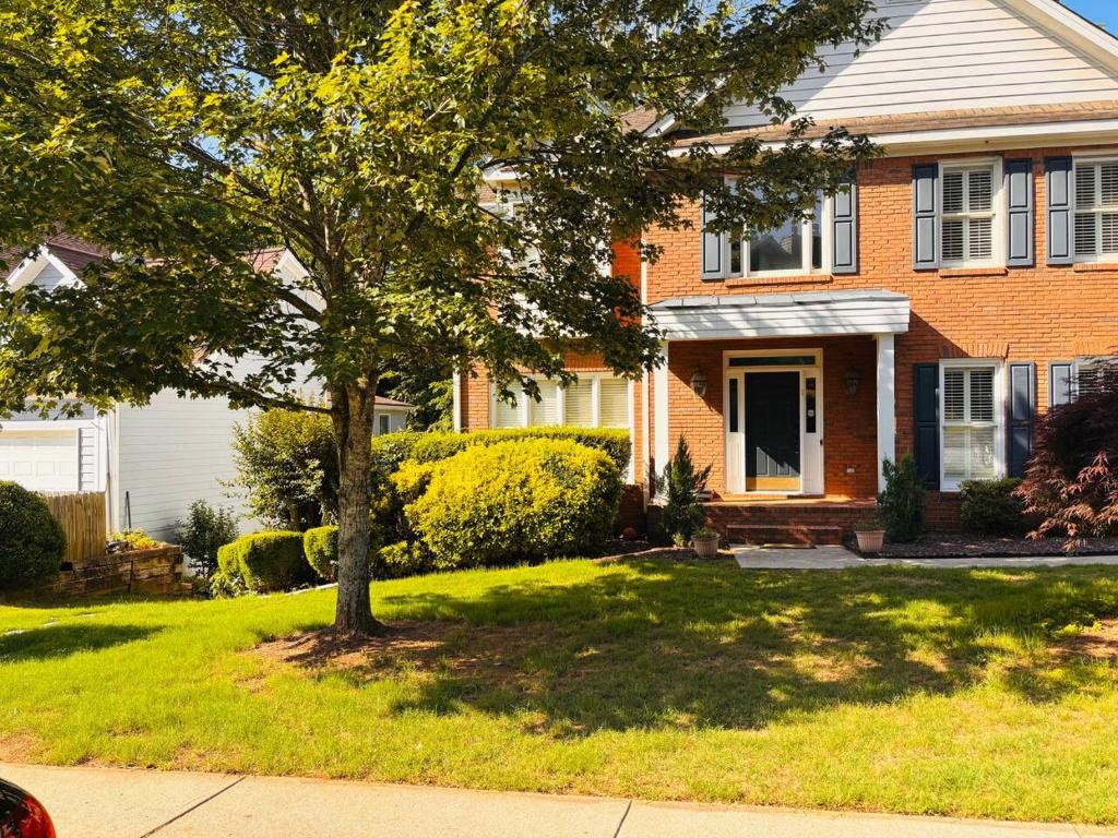 a brick house with a tree in the yard at Studio•Basement• Back Entry Basement•1BRD•Ste B in Lawrenceville