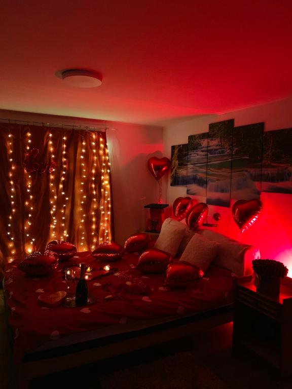 a red room with a bed with christmas lights at Èlmèny Vendègház in Csurgó