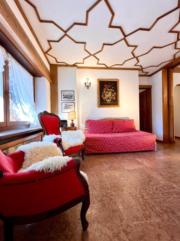 a bedroom with a bed and two chairs at Cortina Relax in Cortina dʼAmpezzo