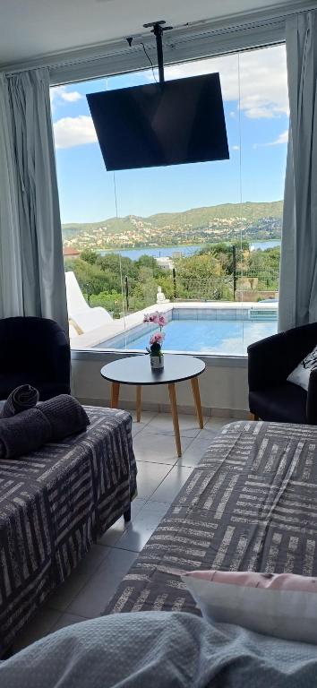 a bedroom with a large window with a view of a pool at Anima Lodge in Villa Carlos Paz