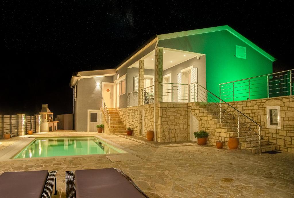 a house with a swimming pool at night at Villa Voka in Acharavi