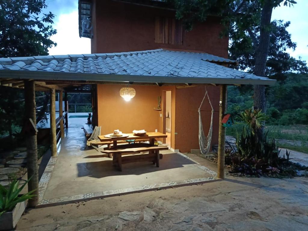 a patio with a picnic table in front of a building at Rancho Primavera in Santana do Riacho