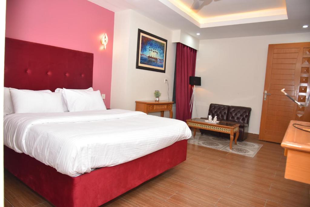 a bedroom with a large bed with a red headboard at River View Hotel in Heart of Muzaffarabad,213 in Muzaffarabad