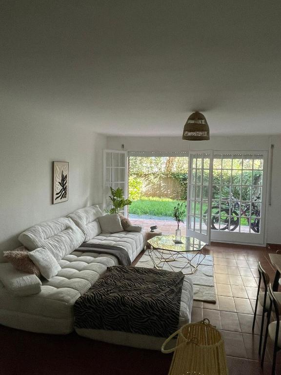 a living room with a white couch and a table at OceanView Shared Apartment in Sant Andreu de Llavaneres
