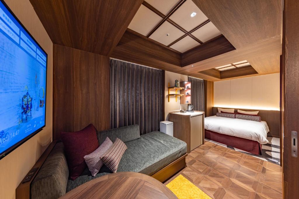a room with a couch and a bed and a tv at Hotel Keihan Asakusa in Tokyo
