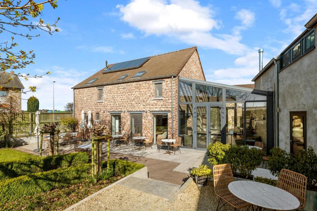 an extension to a brick house with glass doors at Boutique Hotel Het Zoete Zijn in Borgloon