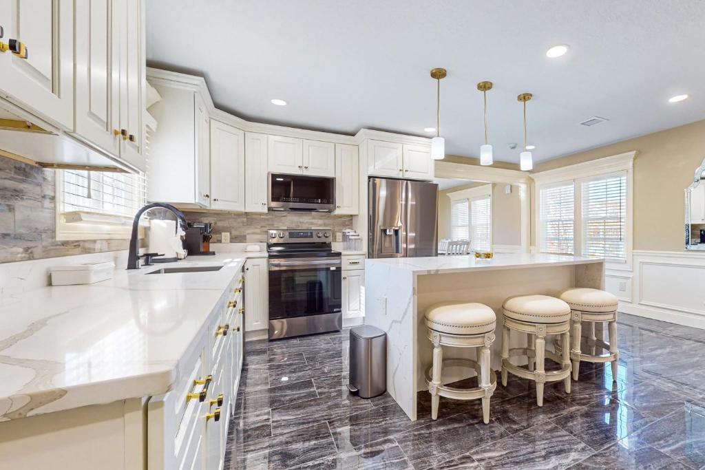 a kitchen with white cabinets and bar stools at Steps to Holyoke Medical Center! Remote-Work Hub in Holyoke
