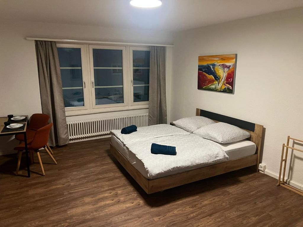 a bedroom with a bed and a desk and a window at Central Living Brugg - Studio 12 in Brugg