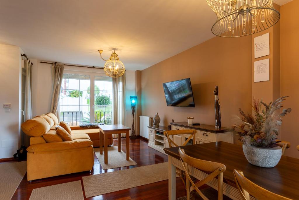 a living room with a couch and a table at Los cuetos, casa para 6 personas con jardín y parking, a pocos minutos de Suances in Suances
