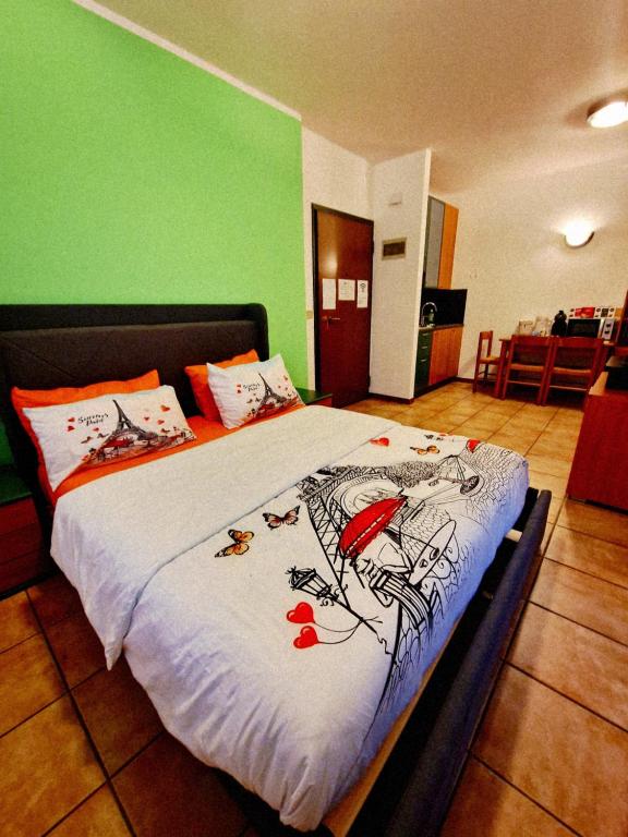 a bed in a room with a green wall at Bernina Stop & Go apartment - 30 steps to the red train in Tirano