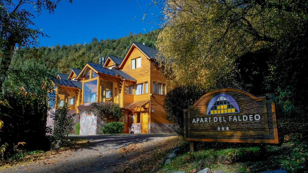 a large wooden house with a sign in front of it at Apart del Faldeo in San Martín de los Andes