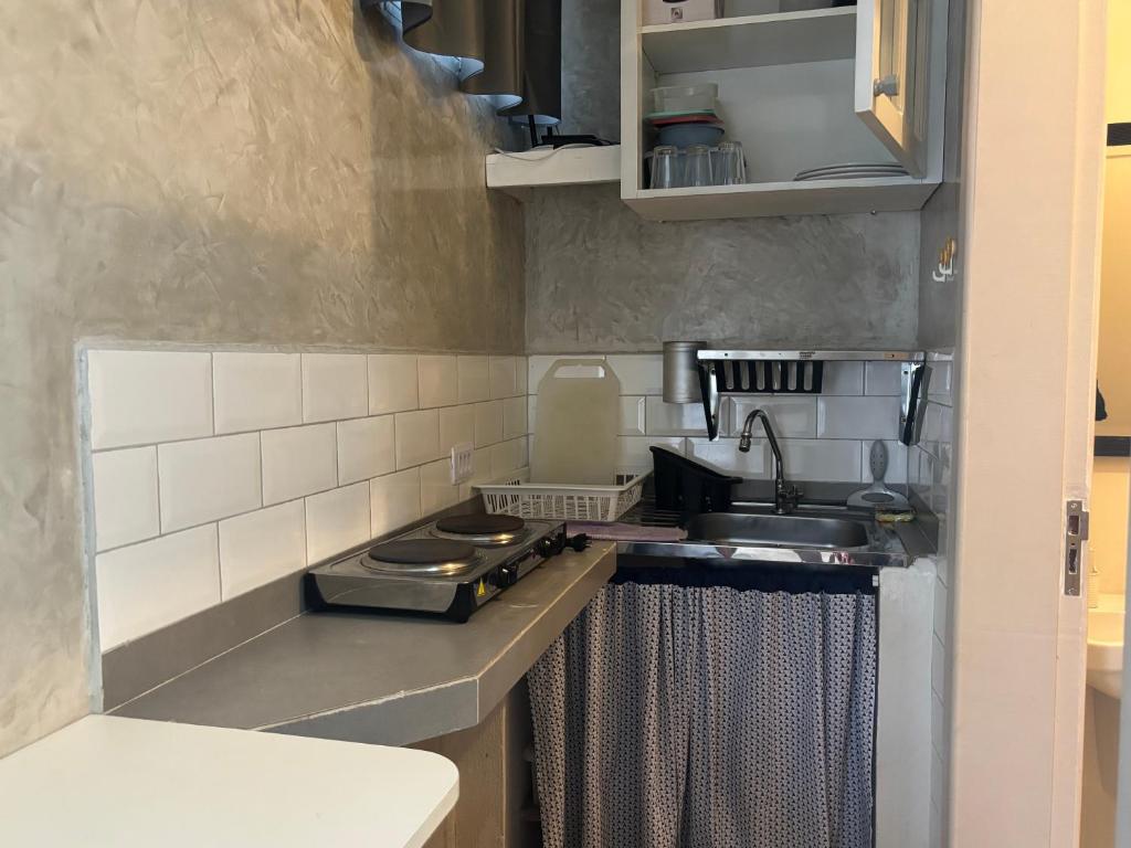 a small kitchen with a sink and a stove at Mini Studio Villaggio juquehy in São Sebastião