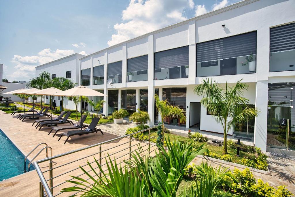 an exterior view of a building with chairs and a pool at Newport Hotel in Atimpoko