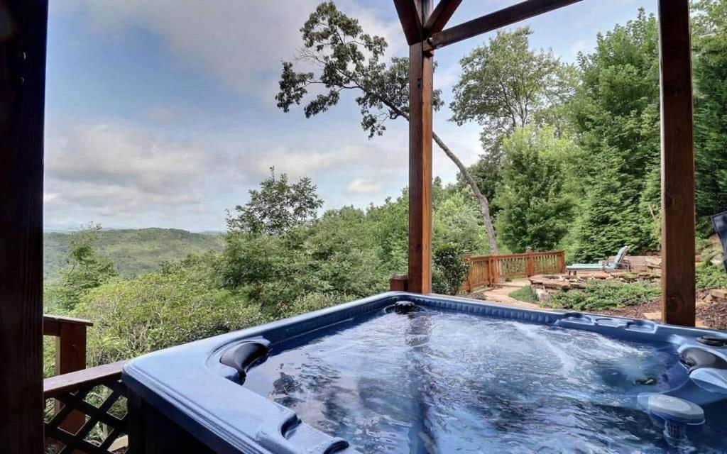 a jacuzzi tub on a deck with a view at Majestic Mountaintop Escape in Blue Ridge