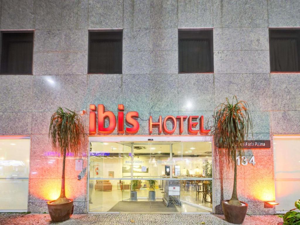 a store front of aldies hotel with two palm trees in front at ibis Copacabana Posto 2 in Rio de Janeiro