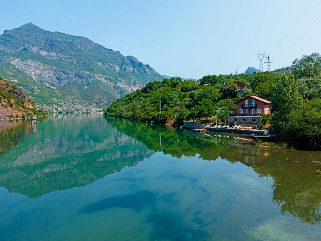 a river with a house on the side of it at Borealis Guest House in Koman