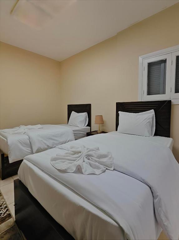 a bedroom with two beds with white sheets at The Cozy Twin Room in Cairo