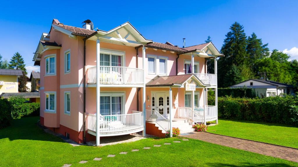 ein großes rosafarbenes Haus mit einem grünen Hof in der Unterkunft Ferienhaus Stefanie in Sankt Kanzian am Klopeiner See