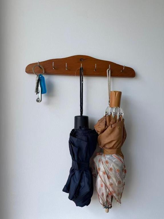 a surfboard and gloves hanging on a wall at Irina's bnb in Auckland