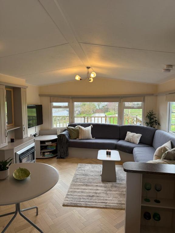 ein Wohnzimmer mit Sofa und Tisch in der Unterkunft Eastington in Lapford