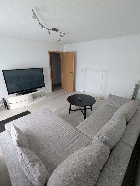 a living room with a couch and a flat screen tv at Apartment Kraft in Aßlar