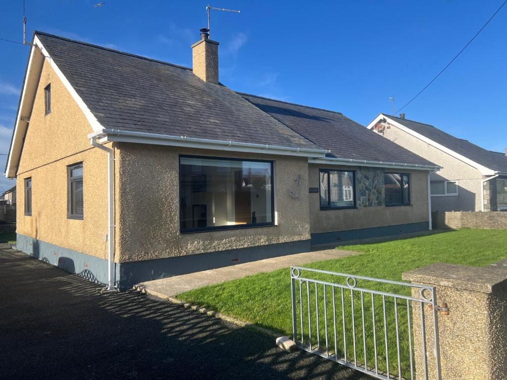 a house with a fence in front of it at Morannedd in Pwllheli
