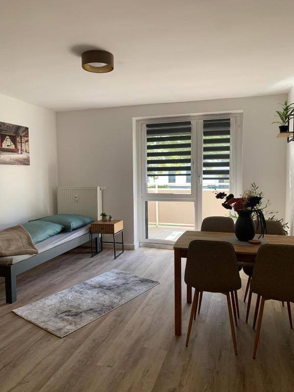 a living room with a bed and a table and chairs at moderne Ferienwohnung Nähe Goitzschesee in Greppin