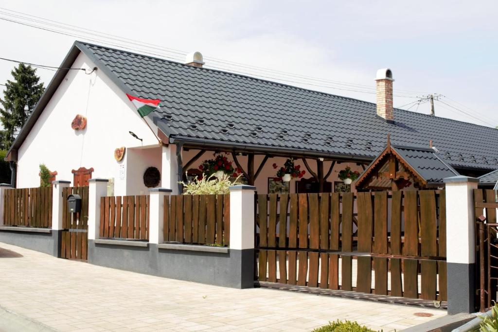 a house with a wooden gate and a fence at Ádi Vendégház - Bekecs in Bekecs