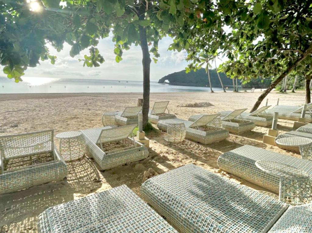 a group of chairs and tables on a beach at Threeos Cabana in Boracay
