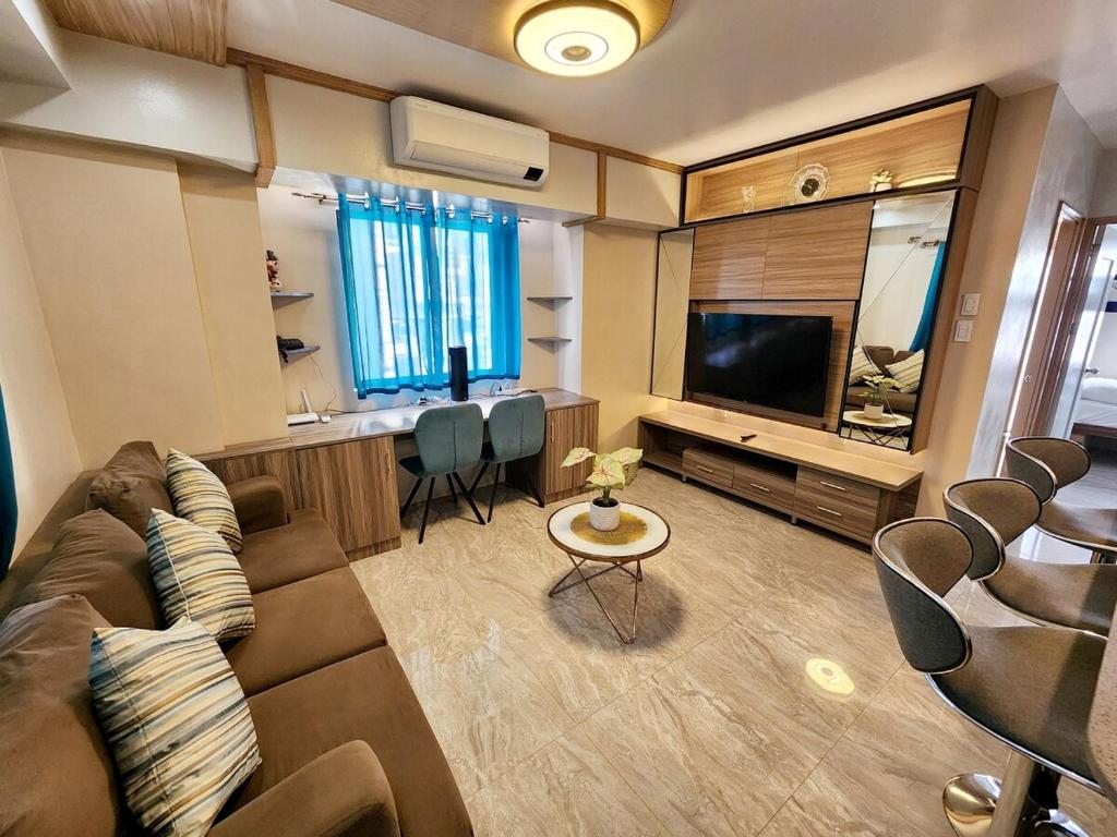 a living room with a couch and a flat screen tv at 2 Bedroom Corner in Davao City
