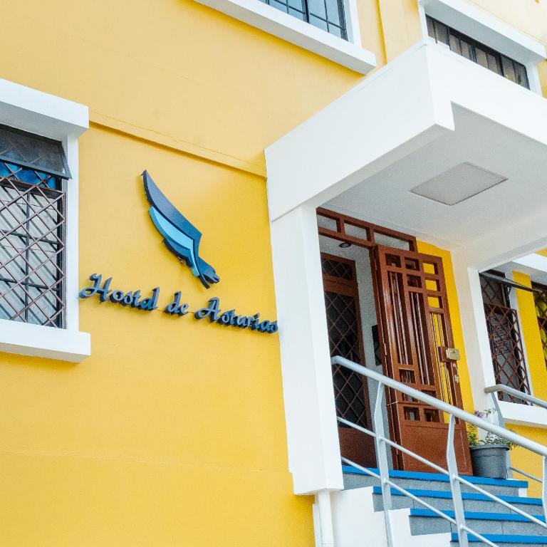 a yellow building with a sign that reads hazard be alarmed at Hostal de Asturias in San Salvador