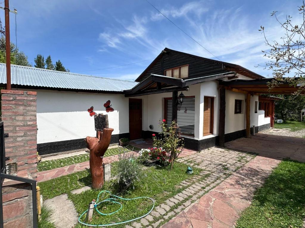 a small white house with a fire hydrant in front of it at Las Palomas in Trevelín