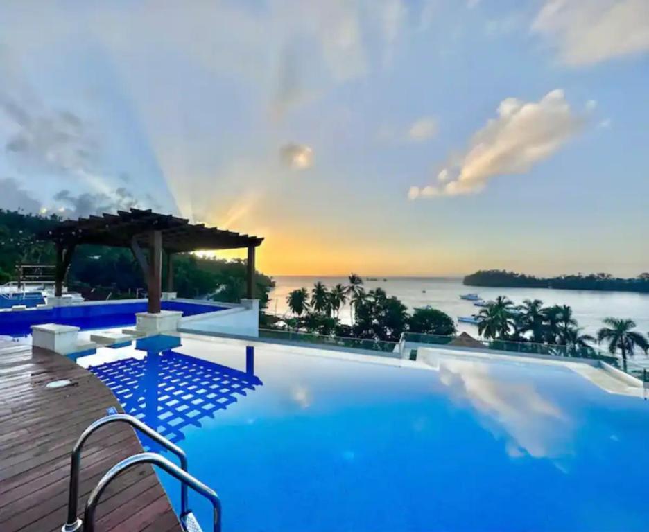 a large swimming pool with a view of the ocean at Beautiful Apartment overlooking Samaná Bay in Cayo Vigía