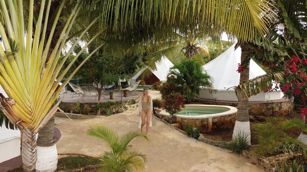 a woman standing next to a pool in a resort at Hameki in Homún