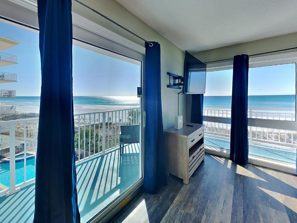 a room with a view of the ocean from a balcony at Aqua Villa #401 in Fort Walton Beach