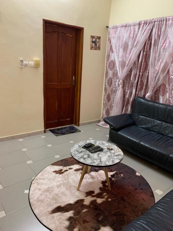 a living room with a couch and a coffee table at VOYALUX BENIN Appartement in Cotonou
