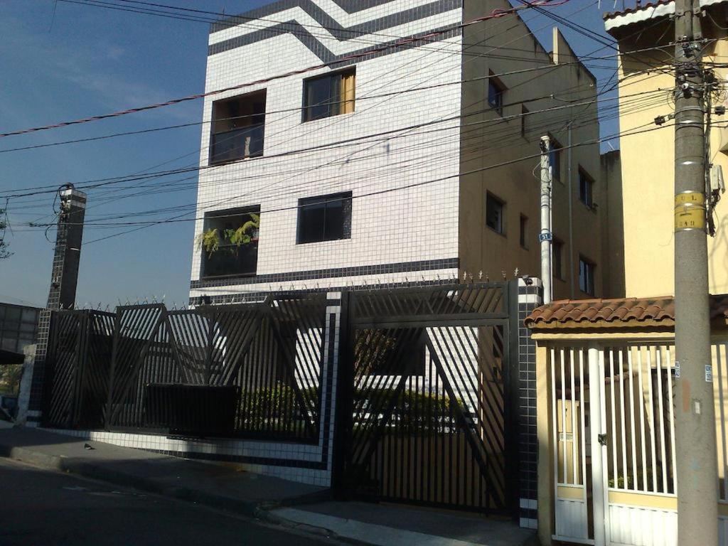 un edificio blanco con una valla delante en Apartamento Guarulhos, en Guarulhos