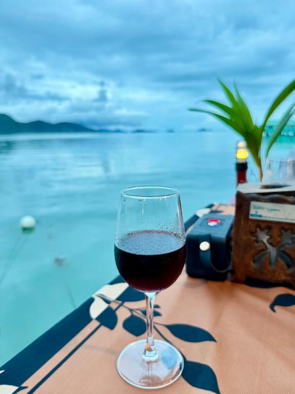a glass of wine sitting on a table next to a pool at Chill House kohchang in Ban Bang Bao