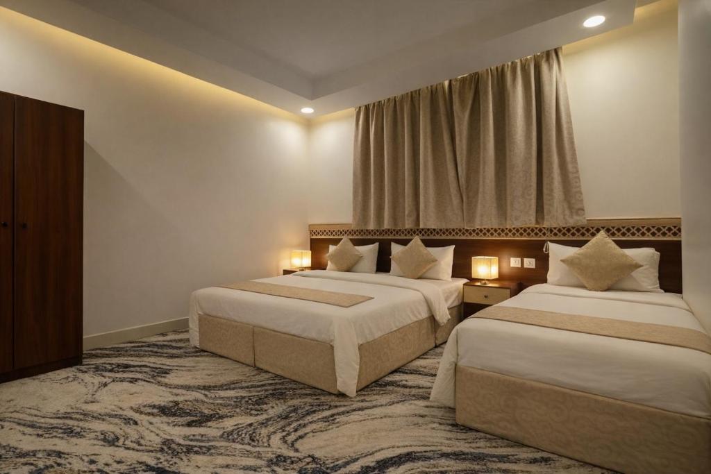 a hotel room with two beds and a window at فندق الروضة المتحدة Hotel AL Rawdah United in Al Khansāk