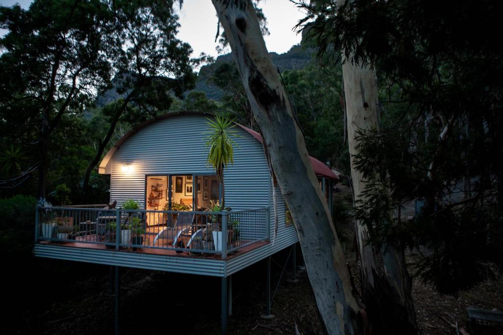 a small house with a tree on a balcony at A Heavenly Escape in Halls Gap