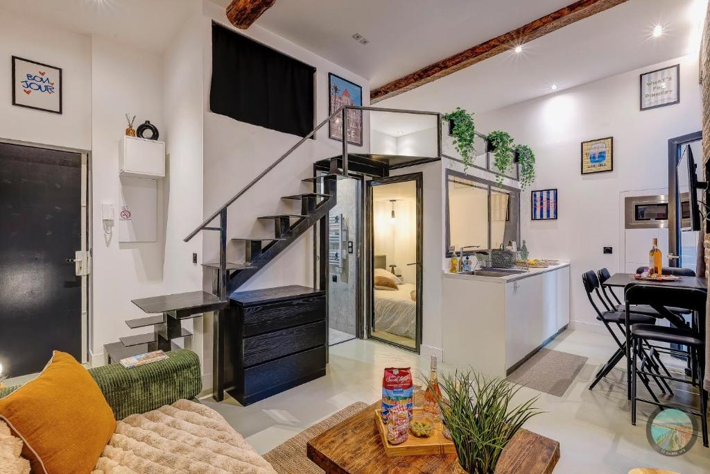 a living room with a staircase leading to a bedroom at Chic Industrial Loft Quiet Garibaldi AC Balcony in Nice