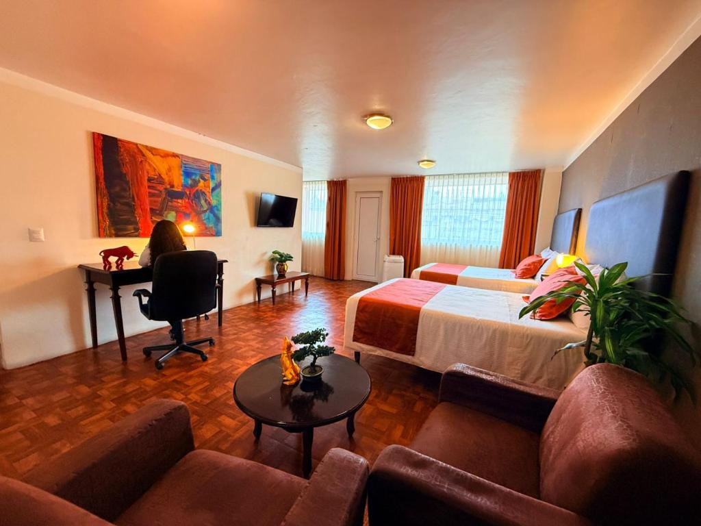 a hotel room with a bed and a desk at Hotel Suites Teziutlan in Teziutlán