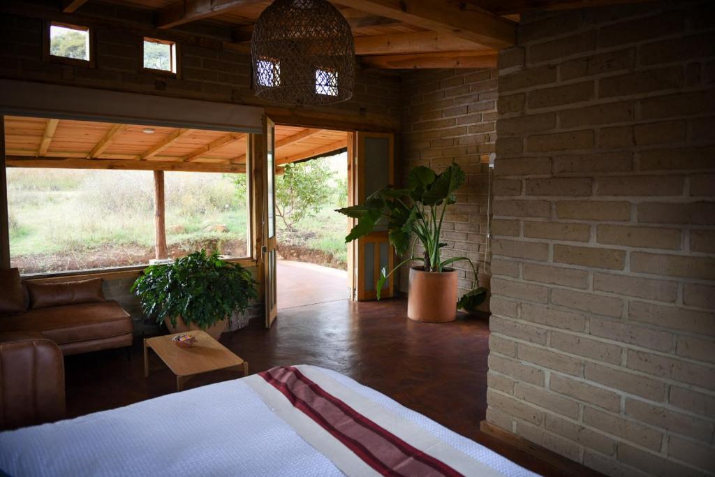 ein Schlafzimmer mit einem Bett und einer Ziegelwand in der Unterkunft Hangar 5 in San Lucas del Pulque