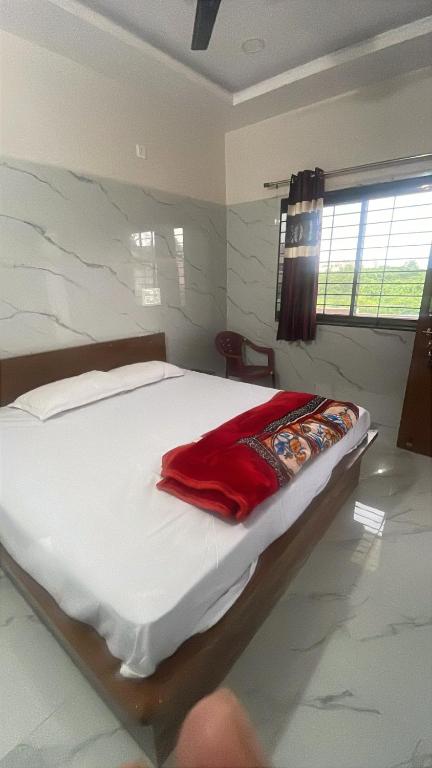 a bedroom with a bed with a red blanket on it at VISHNU DATTA HOMESTAy in Bandanwāda