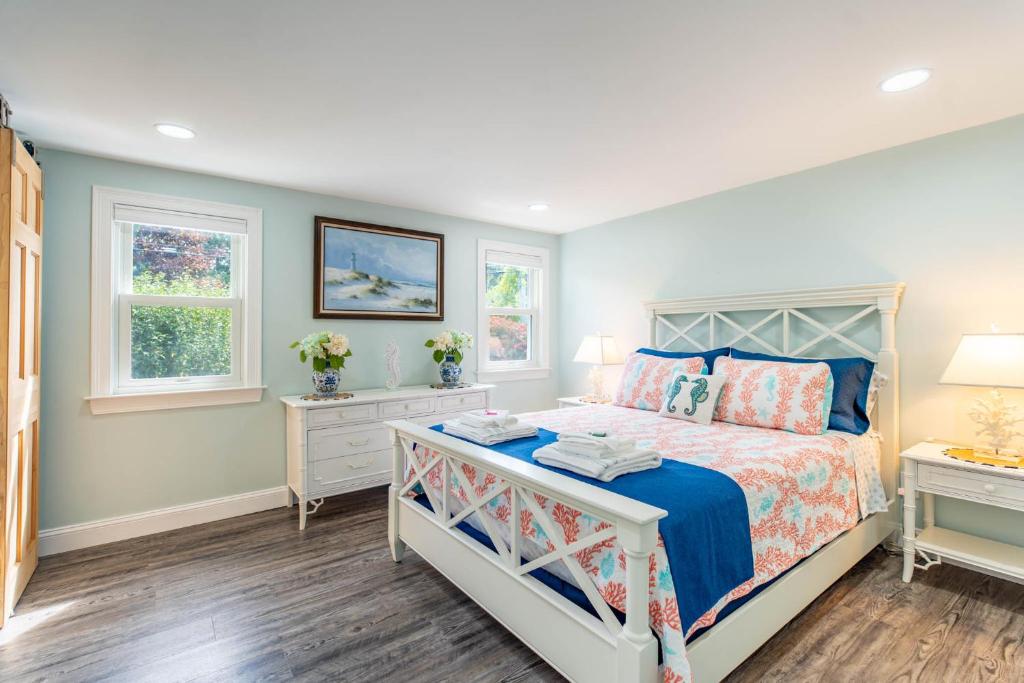 a bedroom with a bed and two windows at Cape Seacret in South Yarmouth