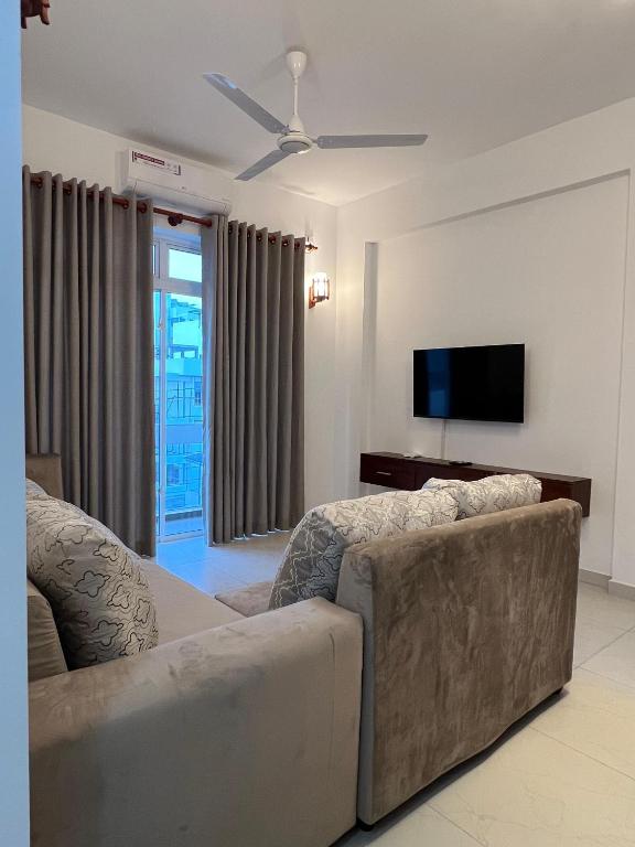 a living room with a couch and a flat screen tv at EZ Colombo Stay in Colombo
